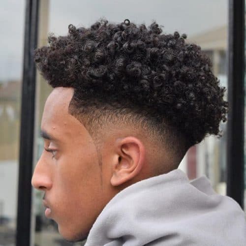 Cool fro hawk fade hairstyle with neatly designed sideburns.