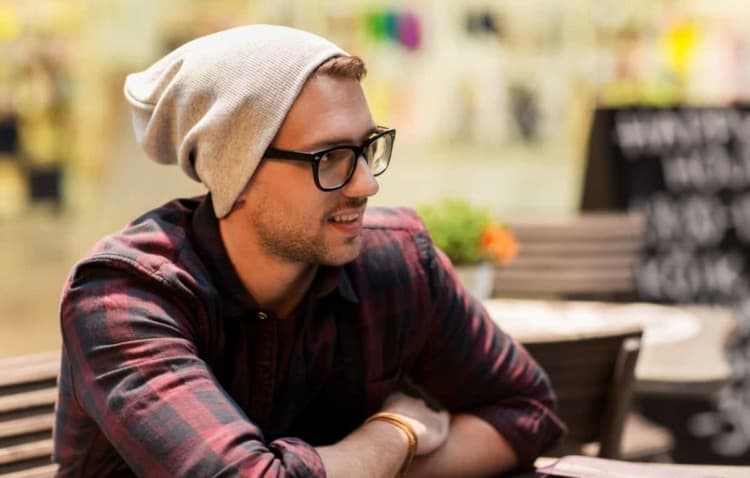 Hipster wearing a beanie and not worried about hair loss