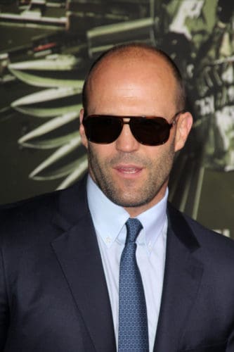 Jason Statham bald with sunglasses and iconic beard.
